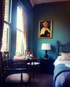 um quarto com uma mesa, uma cama e uma janela em Glendale Hotel em Cardiff
