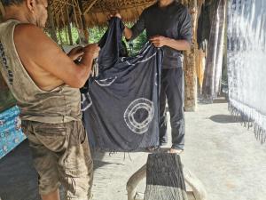 two men are holding a bag in a room at Baan​ Tonlamphu​ Pakpra in Phatthalung