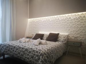 a bedroom with a bed with a large white headboard at SpiderRooms in Naples