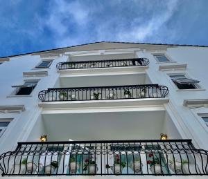 un edificio bianco con balcone con piante di Dalat ECO Hotel 2 a Da Lat