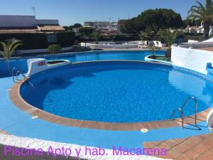 a large swimming pool in a resort with blue water at Residencial Macarena in Matalascañas