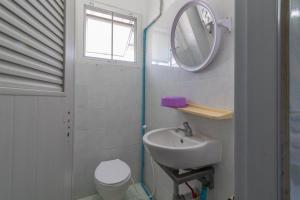 a bathroom with a sink and a mirror and a toilet at New Central Guesthouse in Bangkok