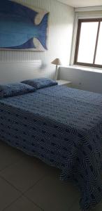 una camera da letto con un letto con una coperta blu e una finestra di Carneiros Beach Resort Tamandaré Flat a Tamandaré Altre 22 foto