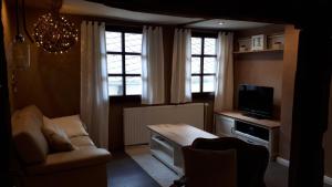 a living room with a couch and a tv at Ferienhaus Strunks ahl Häusje in Alken