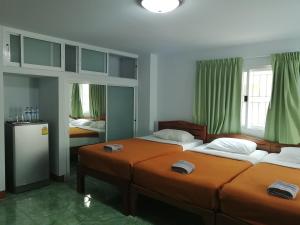 two beds in a room with green curtains at Jardin in Pattaya South