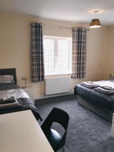 1 dormitorio con 2 camas y ventana en The Woodhouse Inn, en Worksop