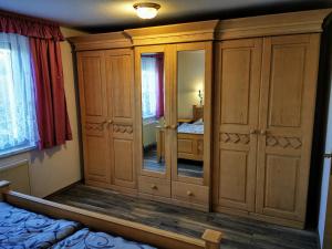 a bedroom with a large wooden cabinet with a mirror at "Elbparadies" Ferienhaus am Niegripper See mit Pool in Burg bei Magdeburg