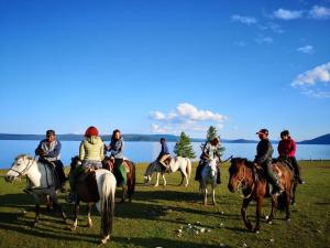 a group of people riding horses in a field at Vast Mongolia Tour Hostel & tours in Ulaanbaatar