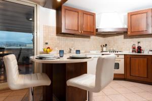 a kitchen with a counter with chairs and a table at The Roof - Appartamento con terrazza al centro di Civitavecchia in Civitavecchia