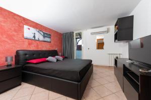 a bedroom with a black bed and a red wall at The Roof - Appartamento con terrazza al centro di Civitavecchia in Civitavecchia