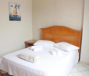 a bed with white sheets and towels on it at APARTAMENTO 3 dormitorio VISTA PARA MAR in Bombinhas