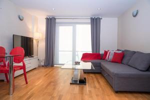 ein Wohnzimmer mit einem grauen Sofa und roten Stühlen in der Unterkunft Tranquil Apartment with Stunning Views in Enfield