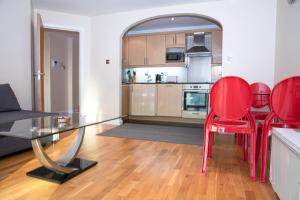 a living room with a glass table and red chairs at Tranquil Apartment with Stunning Views in Enfield