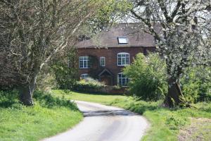 uma estrada em frente a uma casa de tijolos em Pleasance Farm B&B em Kenilworth