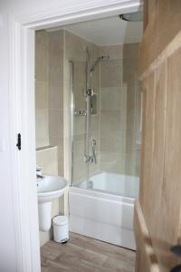 a bathroom with a shower and a tub and a sink at Pleasance Farm B&B in Kenilworth