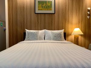 sypialnia z dużym białym łóżkiem i drewnianymi ścianami w obiekcie Chill Chill at Nimman w mieście Chiang Mai