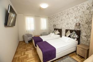 ein Hotelzimmer mit einem Bett und einem TV in der Unterkunft Dóm Hotel in Szeged