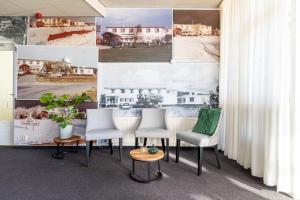 - une salle de réunion avec des chaises blanches et une table dans l'établissement Hotel Ameland, à Nes