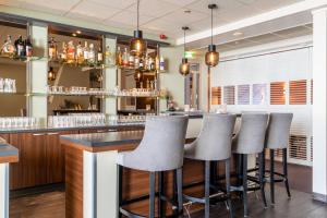 eine Bar mit einer Reihe von Barhockern in einem Restaurant in der Unterkunft Hotel Ameland in Nes