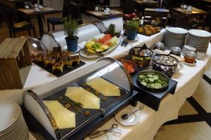a buffet with cheese and other food on a table at Park Hotel am Berliner Tor in Hamburg