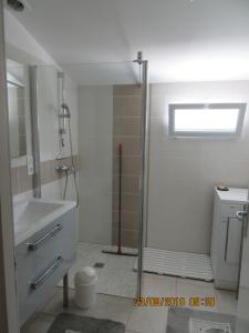 uma casa de banho com um chuveiro e um lavatório. em Location La Brée les Bains 15 personnes em La Brée-les-Bains