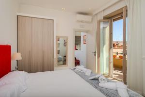 Un dormitorio con una gran cama blanca y una ventana en Many Days Apartments, en Roma