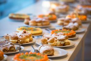 a table topped with plates of pastries and pies at VOI Alimini Resort in Alimini