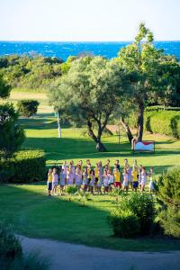 
a crowd of people standing on top of a lush green field at VOI Alimini Resort in Alimini
