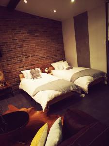 2 Betten in einem Zimmer mit Ziegelwand in der Unterkunft Le Loft in Aulnay-sous-Bois