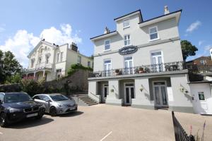 two cars parked in front of a white building at Ascot House Hotel in Torquay
