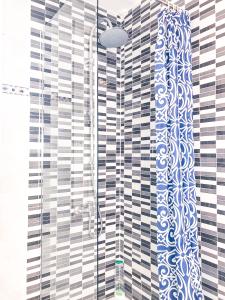 a bathroom with a shower with blue and white tiles at Metropolitan Atocha in Madrid +74 photos