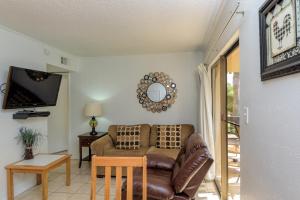 uma sala de estar com um sofá e uma televisão em Tiki 103 em South Padre Island