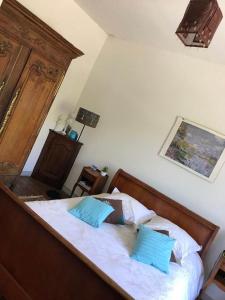 ein Schlafzimmer mit einem Bett mit zwei blauen Kissen in der Unterkunft VILLA JULIETTE DANS LA BAIE DU MONT-SAINT-MICHEL in Saint-Jean-le-Thomas