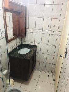 La salle de bains est pourvue d'un lavabo et d'un miroir. dans l'établissement Apartamento Meia Praia - Itapema, à Itapema