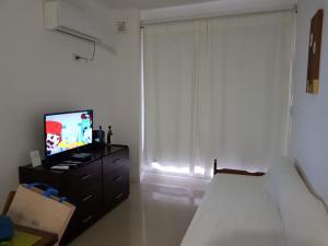 1 dormitorio con 1 cama, TV y ventana en INES en Buenos Aires