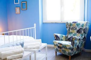 Cette chambre bleue comprend une chaise et un lit. dans l'établissement Villa Aurelia - Seafront Apartment with Terrace, à Flumini di Quartu