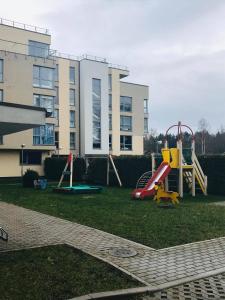 un parco giochi con scivolo in un cortile accanto a un edificio di Saulkrastu nams a Zvejniekciems