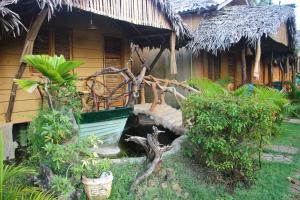 een huis met een veranda met een bos planten bij Nature Beach Huts in Trincomalee