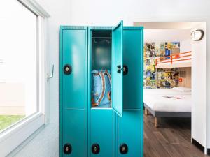 ein blauer Schrank in einem Zimmer mit einem Bett in der Unterkunft hotelF1 Chambéry Nord Rénové in Chambéry