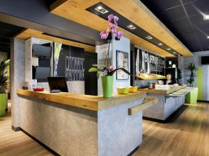 a restaurant with a counter with flowers on it at ibis Budget Villemomble in Villemomble