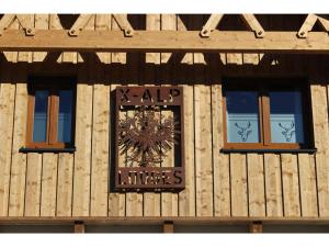 eine Uhr an der Seite eines Gebäudes mit Fenstern in der Unterkunft X-Alp Lodges in Sautens