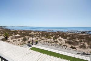 a view of the beach from the balcony of a house at True North West Coast in St Helena Bay
