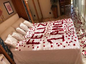 a large cake with red flowers on a bed at Mansion Aline in Rio de Janeiro