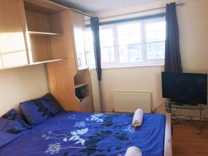 Dormitorio pequeño con cama y TV en My-Places Abbotsfield Court Townhouse 4, en Mánchester