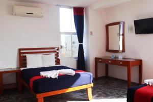 1 dormitorio con 2 camas, espejo y ventana en Hotel Soberanis, en Cancún