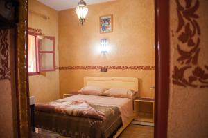 maison de vacance في تافراوت: غرفة نوم صغيرة مع سرير في غرفة