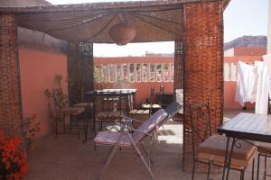 Cette chambre dispose d'une terrasse avec une table et des chaises. dans l'établissement maison de vacance, à Tafraout