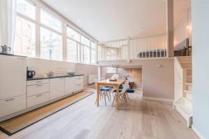 a large kitchen with a table and some chairs at Hip split level apartment on the ground floor in Amsterdam