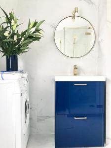 a bathroom with a blue cabinet and a mirror at Apartament BIANCO BLU pod Jasną Górą. in Częstochowa