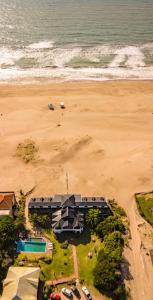 una vista aérea de una playa con un edificio y el océano en Rincón del Mar Apart Hotel, Spa & Resort en Las Gaviotas